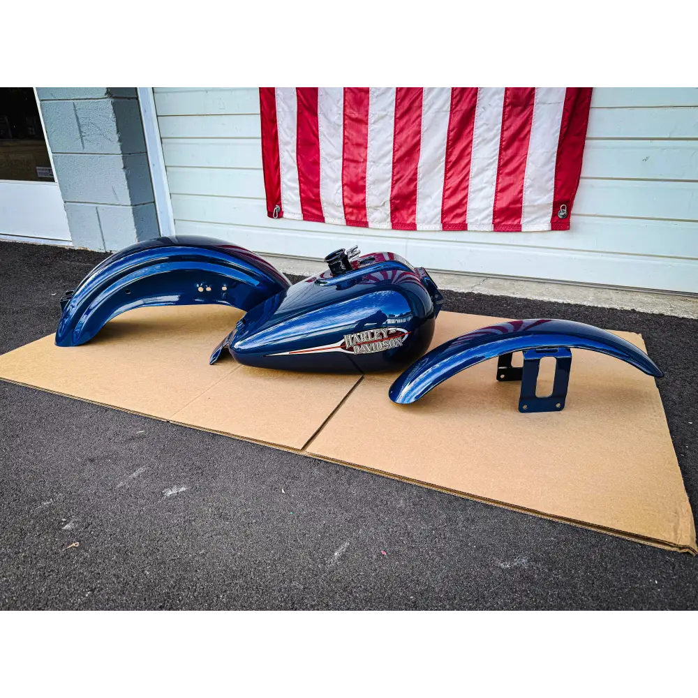 A set of dark blue motorcycle fenders and a fuel tank.