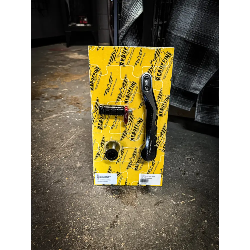 Motorcycle foot controls on yellow packaging.